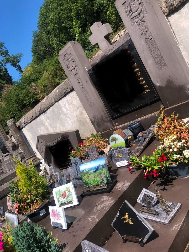 Plaques et fleurs remises en ordre sur une sépulture entretenue, Orcival